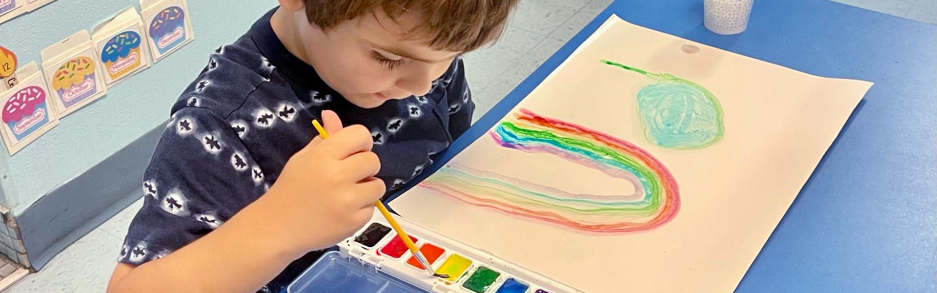 little boy painting a rainbow